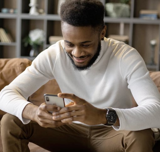 Man texting on a couch