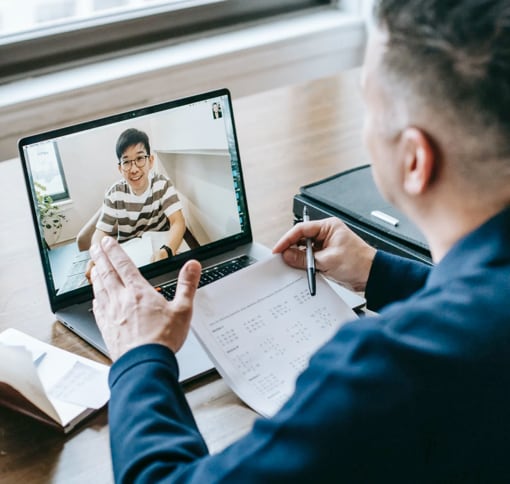 A man interviewing a anther man on a laptop